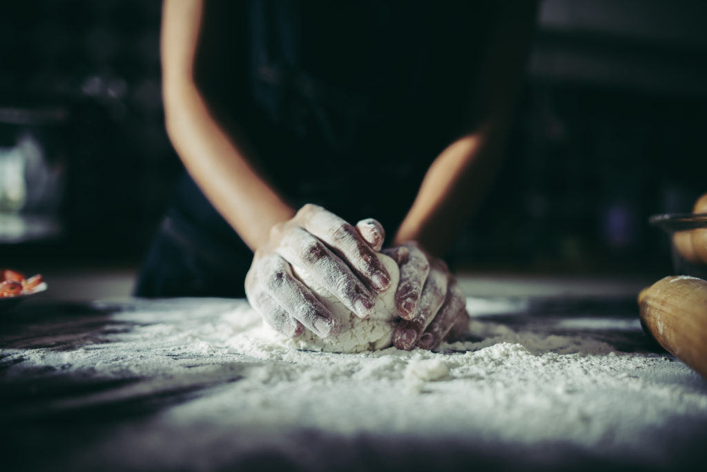 woman kneads dough for make pizza on wooden cooking concept